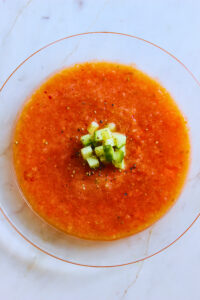overhead image of cold gazpacho served in a glass bowl