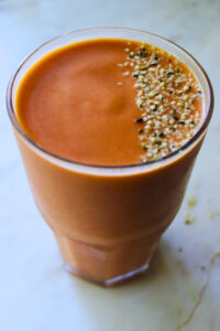 image of mamey shake in a glass cup topped with hemp seeds