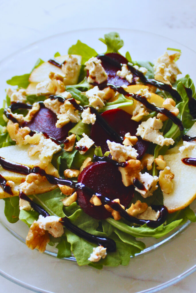 image of arugula, tofu feta, pear, beet salad