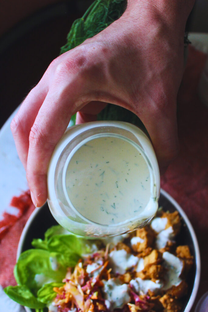 image of dill pickle dressing being used on a nourish nowl