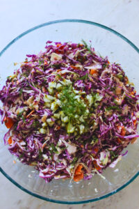 overhead image of a large glass bowl of dill pickle coleslaw
