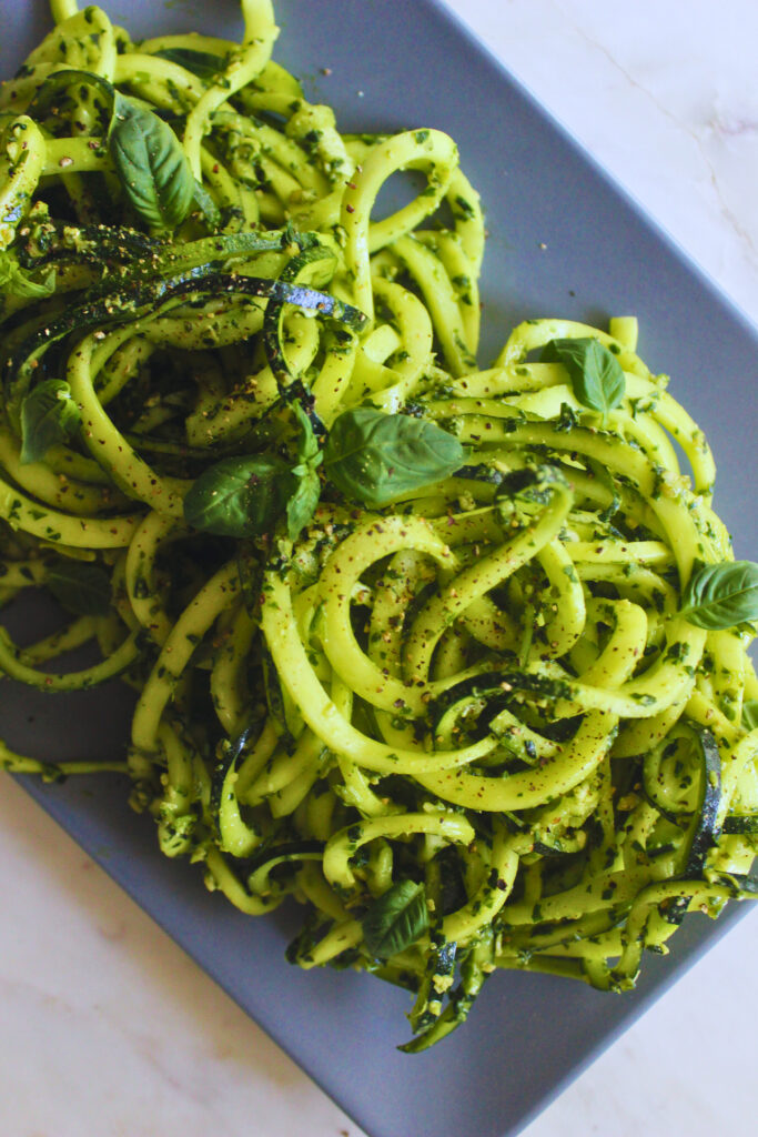 image of raw zucchini noodles and pesto