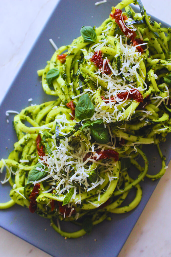 image of raw zucchini noodles and pesto