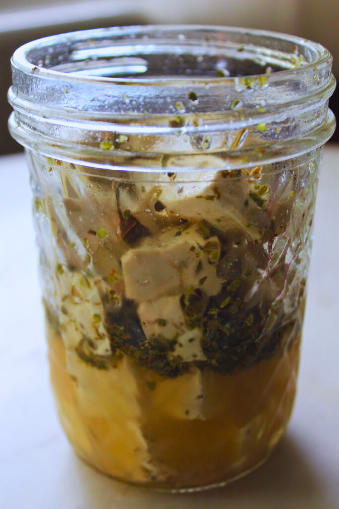 cubed tofu marinated in a glass jar