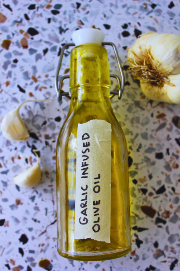 overhead image of garlic infused oil in a glass bottle
