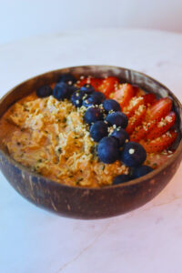 image of overnight oats topped with strawberries, blueberries and hemp seeds