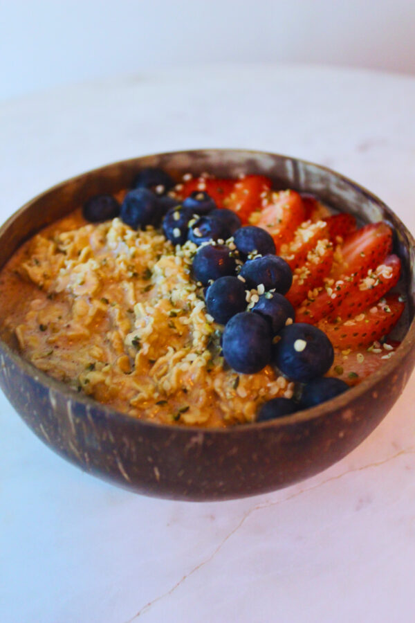 image of overnight oats topped with strawberries, blueberries and hemp seeds