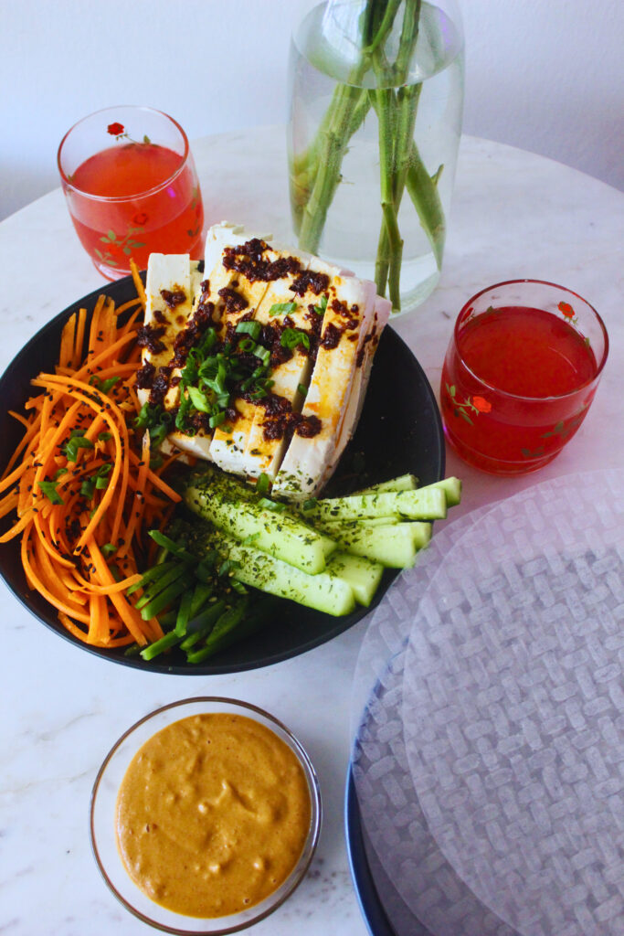 image of a table set with drinks and a platter of tofu with fresh veggies