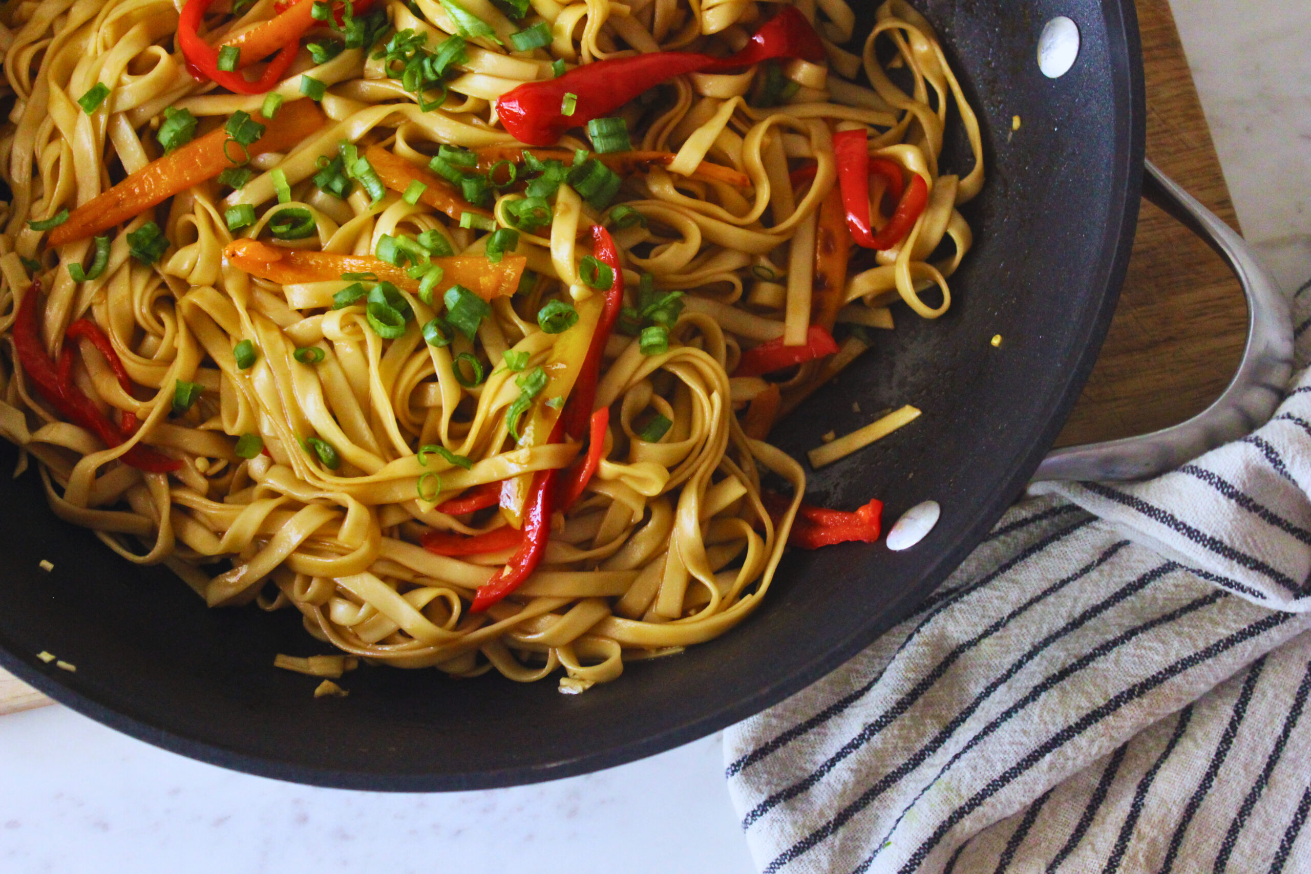 vegan teriyaki noodles topped with veggies and green onion