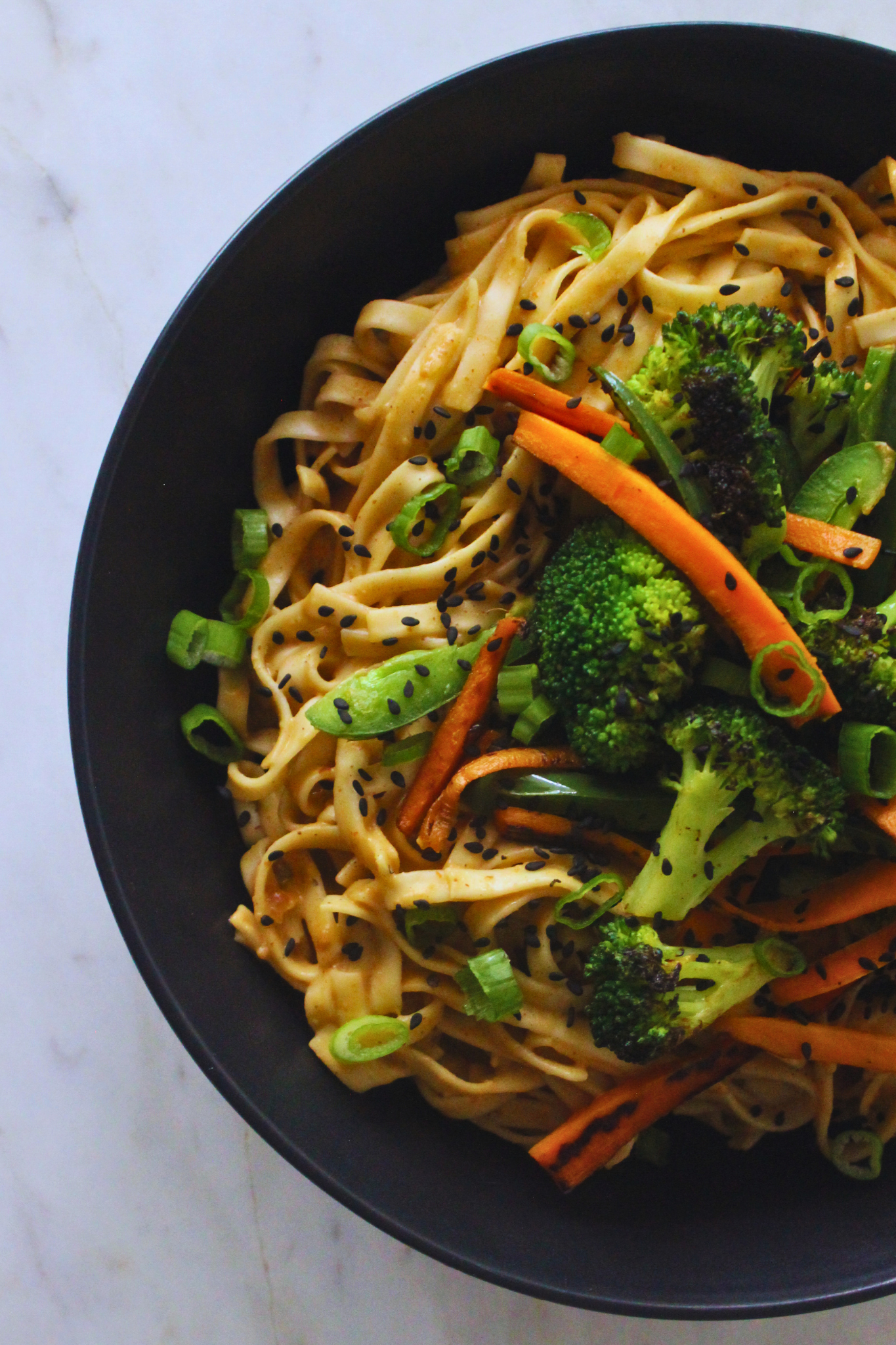 overhead image of peanut noodles topped with veggies