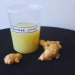 Image: Fresh ginger juice in container with fresh ginger root as decor