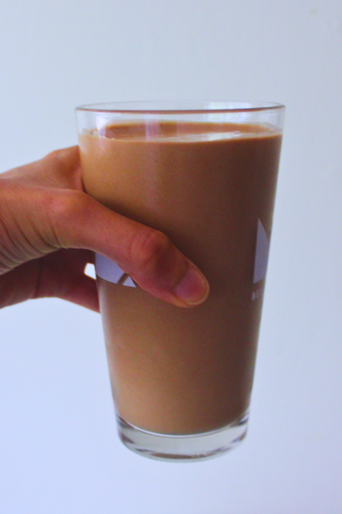 image of hand holding pint of chocolate banana smoothie