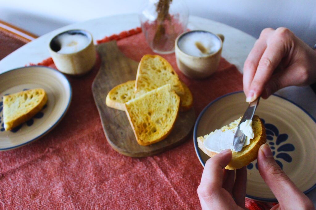 Image of hands spreading vegan cream cheese over toast