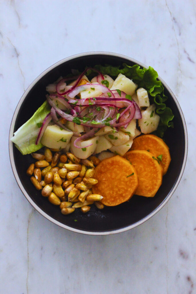 Overhead Image of Vegan Ceviche over a lettuce leaf, with canchitas and wheel slices of boiled sweet potato.