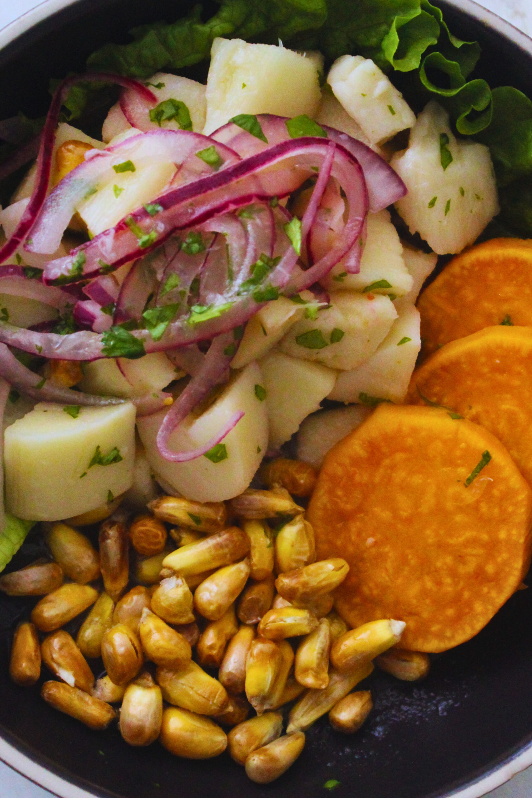 Plated Peruvian ceviche with canchitas, sweet potato slices and fresh vegan ceviche