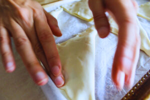 Image of hands pressing on pastry dough to seal