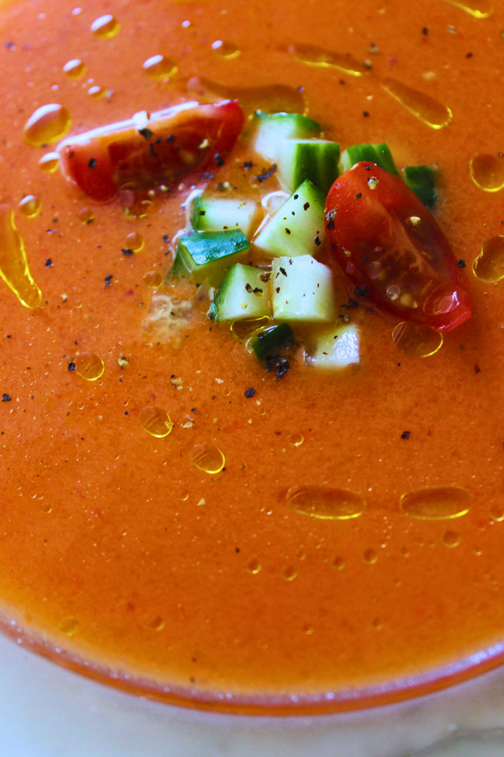 gazpacho served topped with diced cucumber, tomato and a drizzle of olive oil