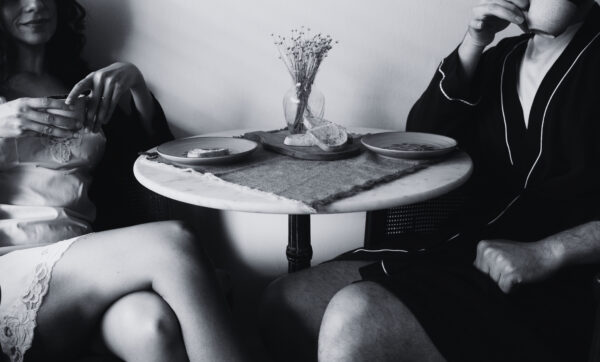 Black and white image of a couple having breakfast at a bistro table