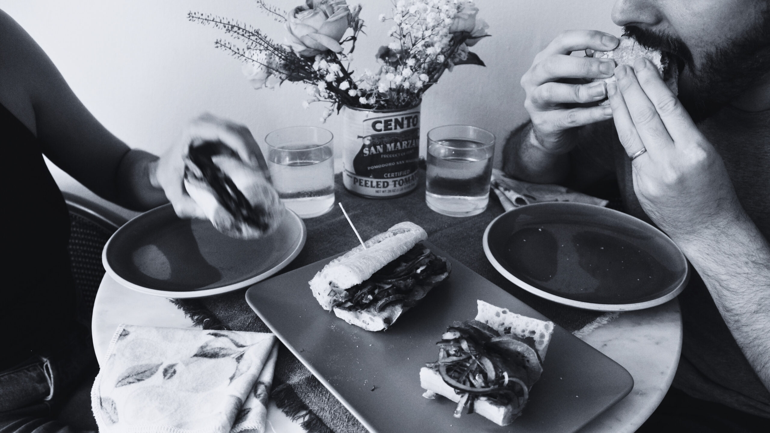 black and white image of two people eating choripans