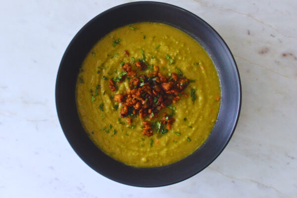 overhead image of slip pea soup topped with smokey tempeh crumble and chopped parsley