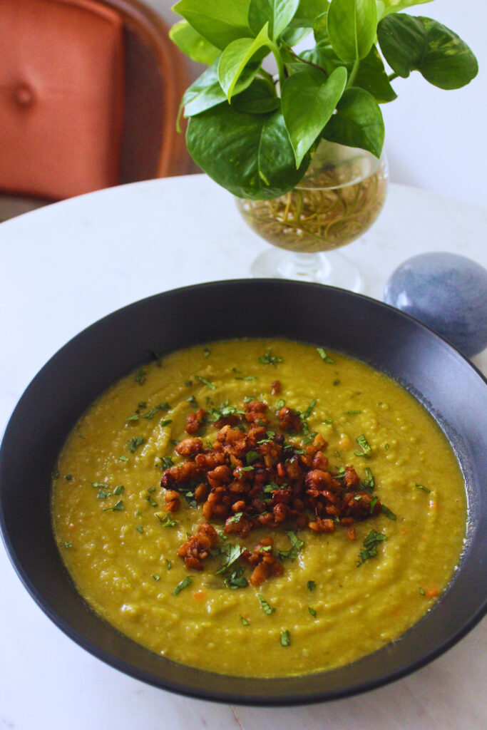 split pea soup topped with smokey tempeh crumble and chopped parsley