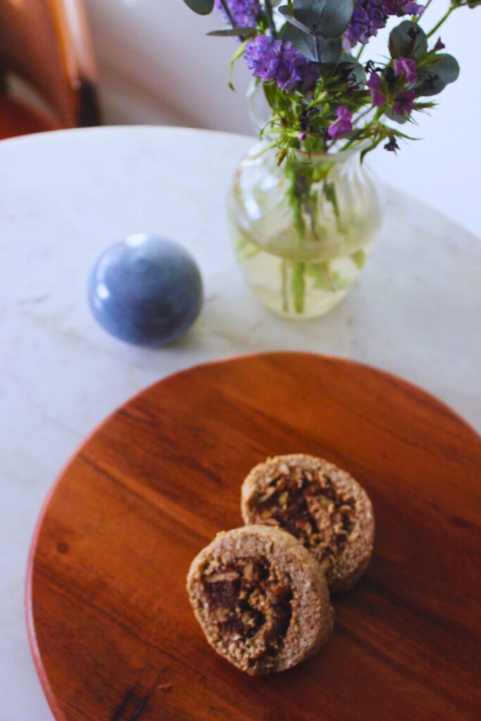 image of table with flowers and raw cinnamon rolls on a wooden board