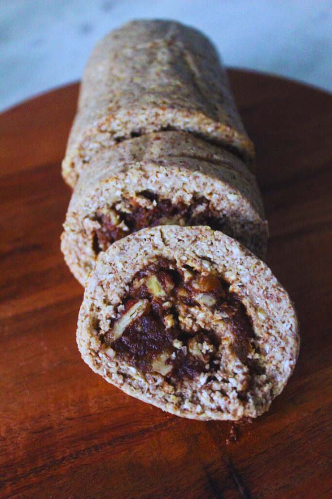 image of raw cinnamon roll log with two pieces cut