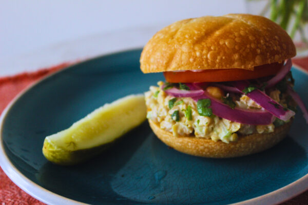 vegan tuna sandwich with a side pickle