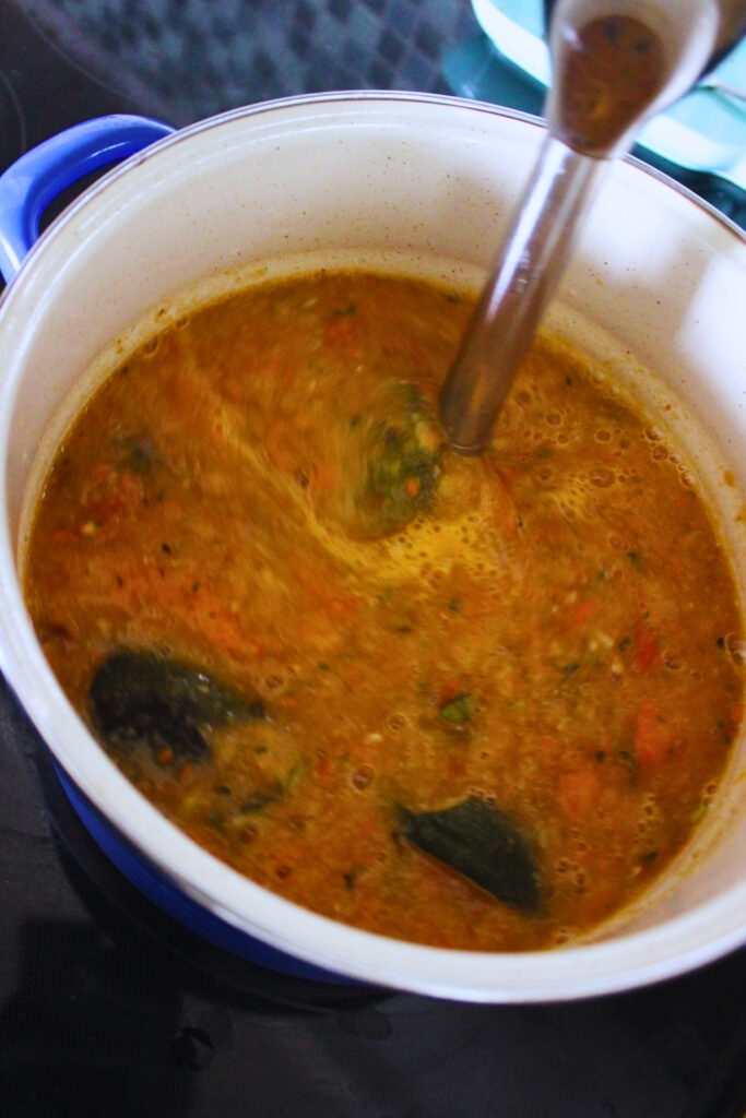 image of roasted veggie soup being blended with an immersion blender