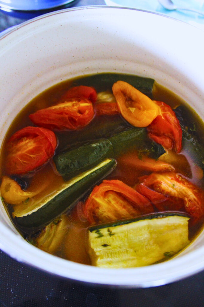 image of roasted veggies in a pot with vegetable broth