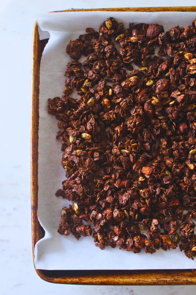 overhead image of homemade chocolate granola on a baking sheet