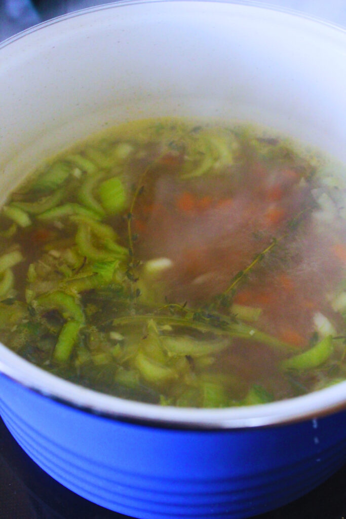 image of white bean soup ingredients being cooked with broth