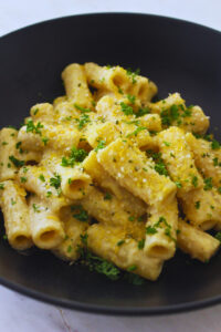 image of creamy cheesy bean and cashew pasta with fresh pasley