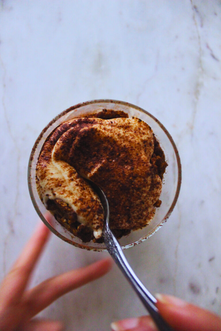 image of hands and spoon digging into a vegan tiramisu cup