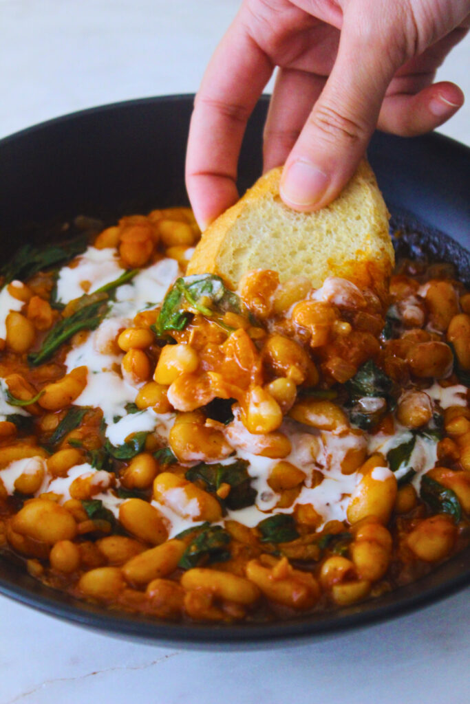 image of bread scooping up some creamy white bean