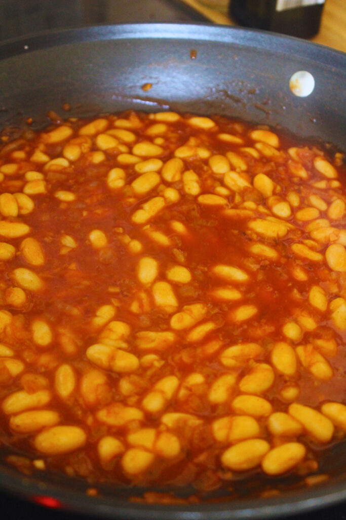 image of white beans being cooked in tomato paste