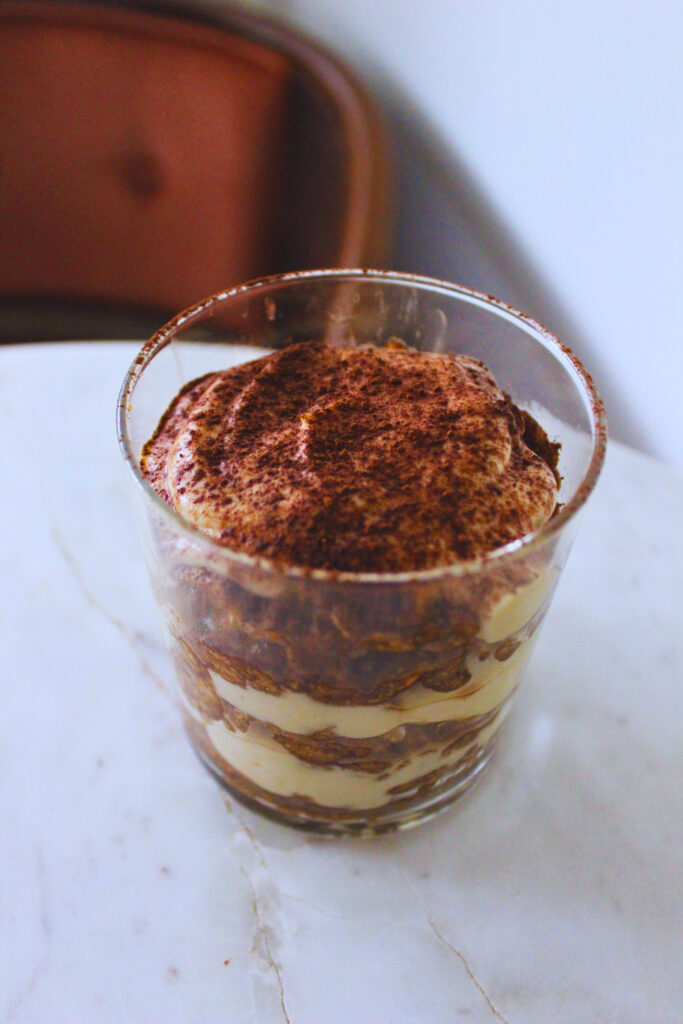 image of a vegan teramisu cup on a marble table