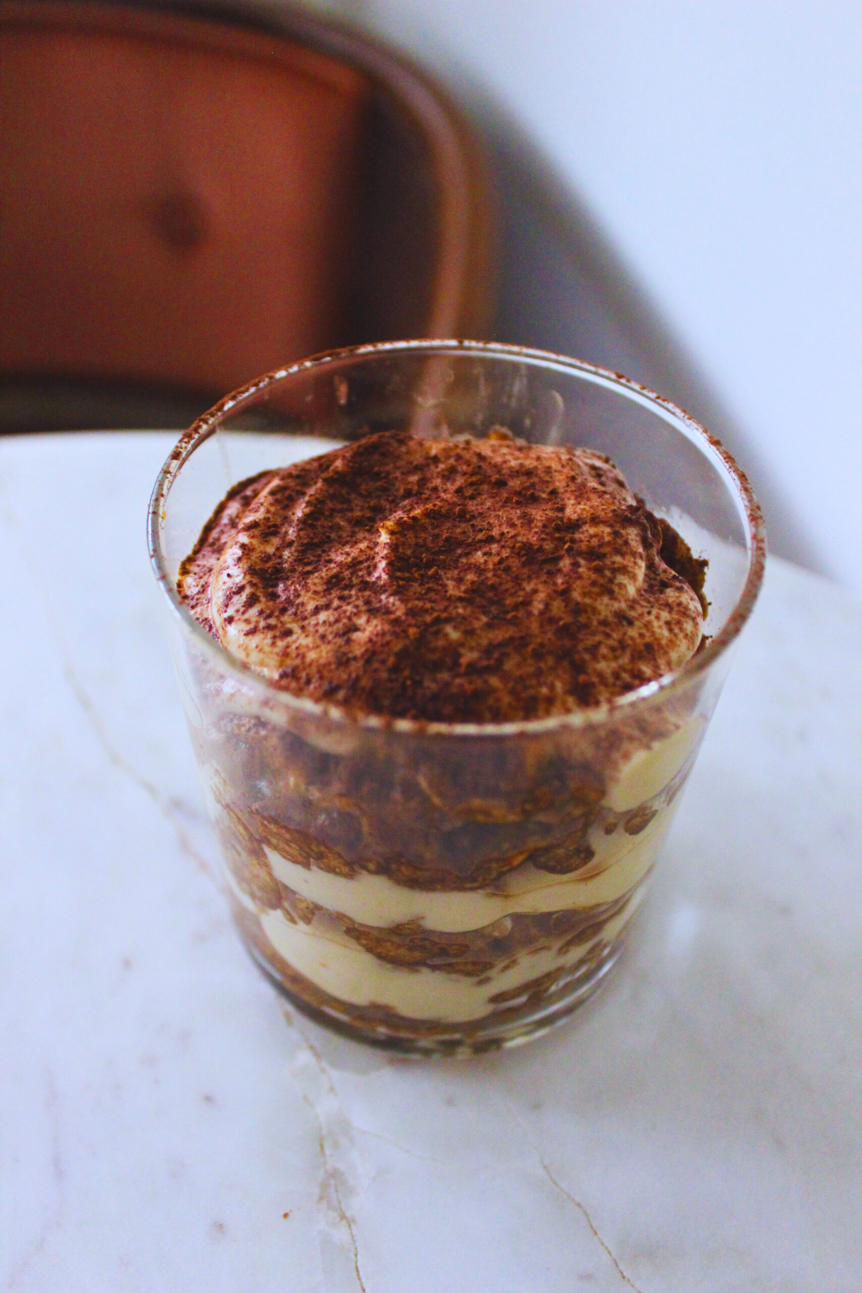 image of a vegan teramisu cup on a marble table