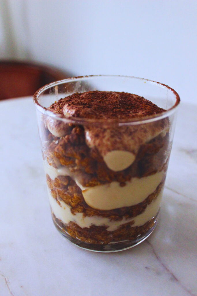 layered tiramisu cup on marble cafe table