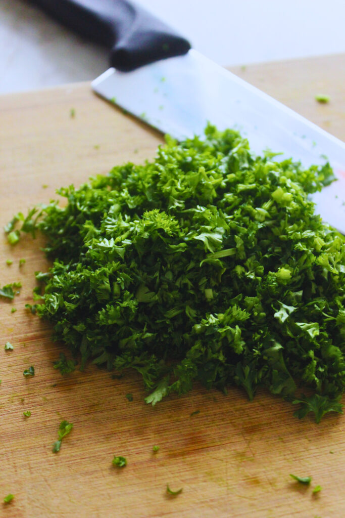 freshly chopped parsley on a cutting board with a chef knife