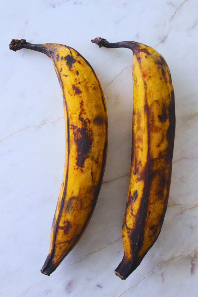 overhead image of two ripe plantains with black spots