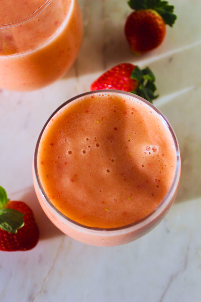 image of strawberry banana apple smoothie in a glass cup on an early morning 