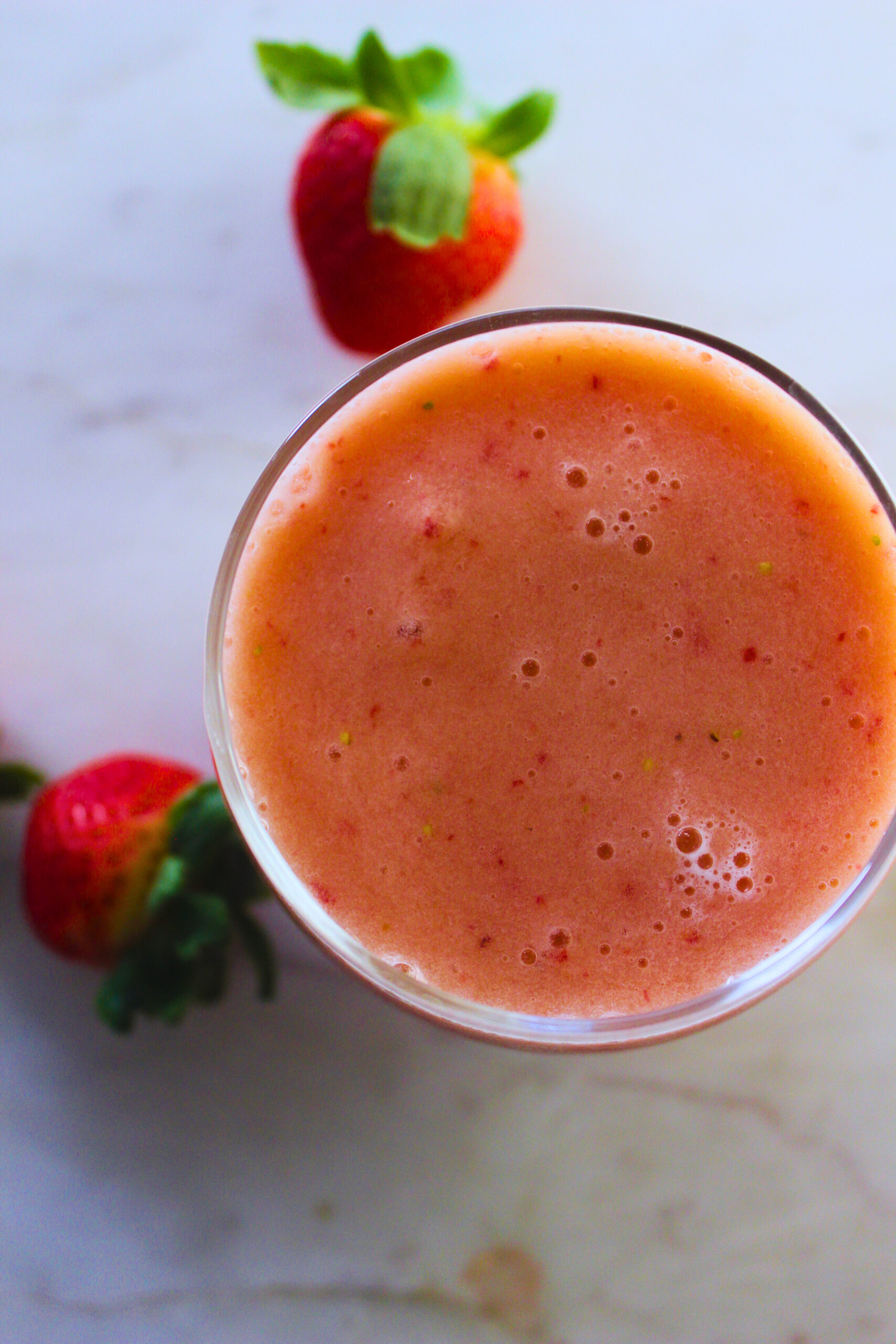 overhead image of a refreshing smoothie with fresh strawberries