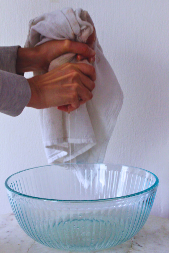 image of hands squeezing jackfruit that is wrapped in a clean kitchen towel