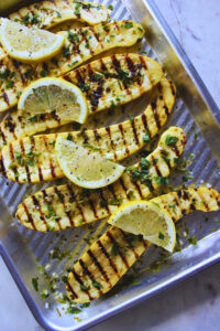 Grilled yellow squash with lemon parsley sauce and topped with fresh lemon wheels