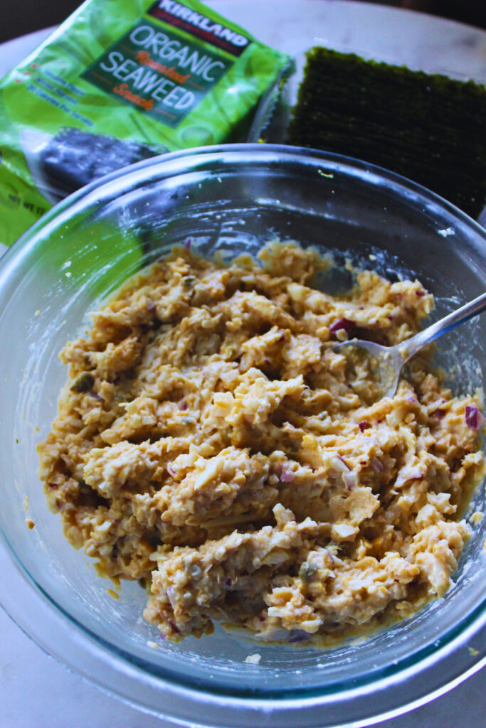 image of creamy chickpea paste in a glass bowl with side package of seaweed snack sheets