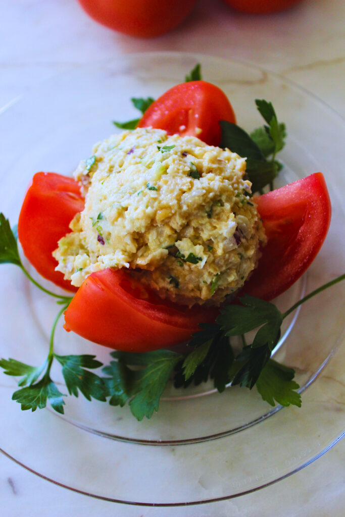 Vegan "tuna" stuffed tomato garnished with parsley