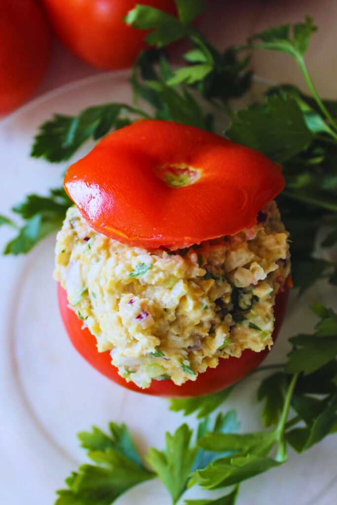 Vegan "tuna" stuffed tomato garnished with parsley