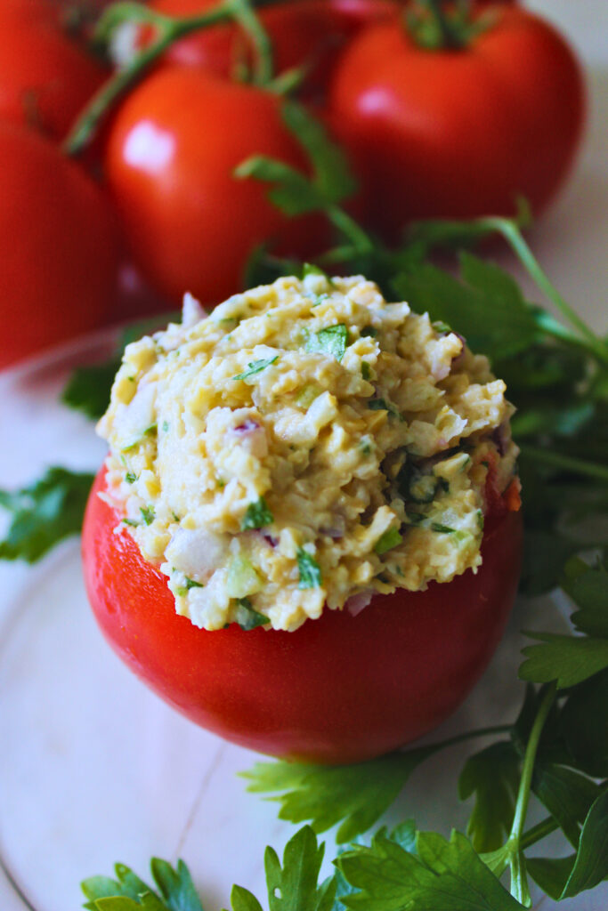 Vegan "tuna" stuffed tomato garnished with parsley